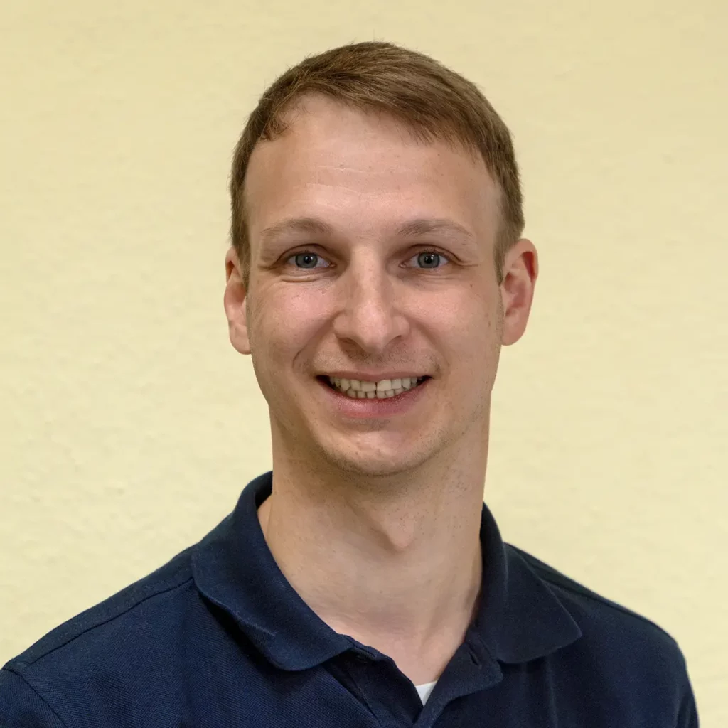Christian Eck, Inhaber der Zahnarztpraxis Christian Eck: junger Mann mit kurzen dunkelblonden Haaren in blauem Polohemd